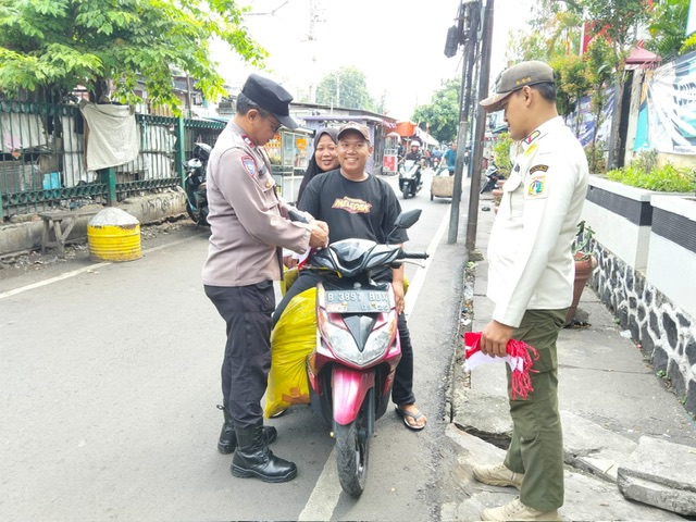 Bhabinkamtibmas Pekojan Semarakkan HUT RI ke-80 dengan Bagikan Bendera Merah Putih